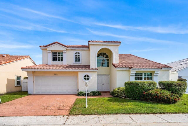 mediterranean / spanish house featuring a garage and a front lawn