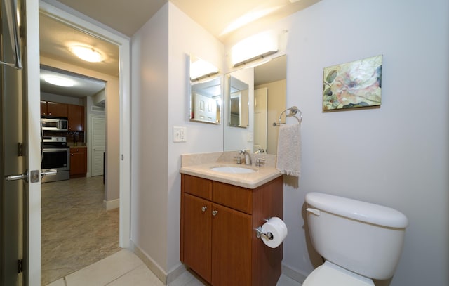 bathroom with tile patterned floors, vanity, and toilet