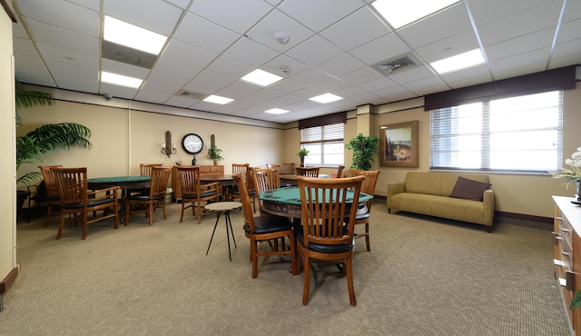 carpeted dining area featuring a drop ceiling and a wealth of natural light