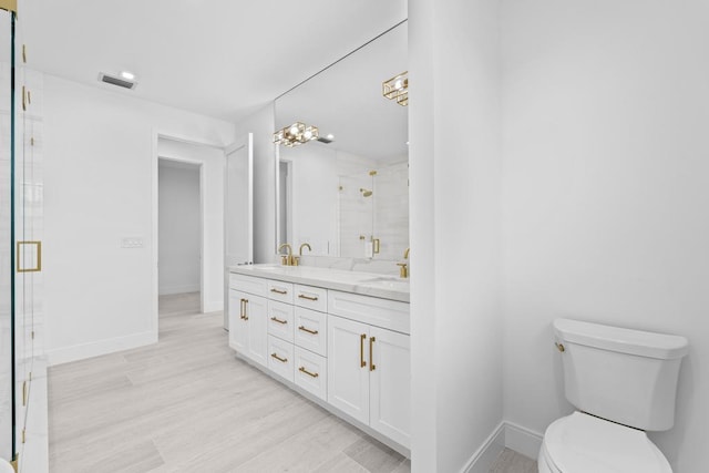 bathroom featuring vanity, hardwood / wood-style floors, a shower with door, and toilet