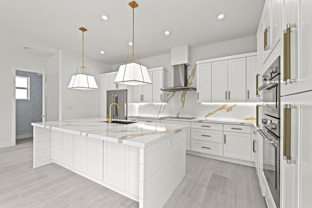 kitchen with white cabinets, decorative light fixtures, and a large island with sink