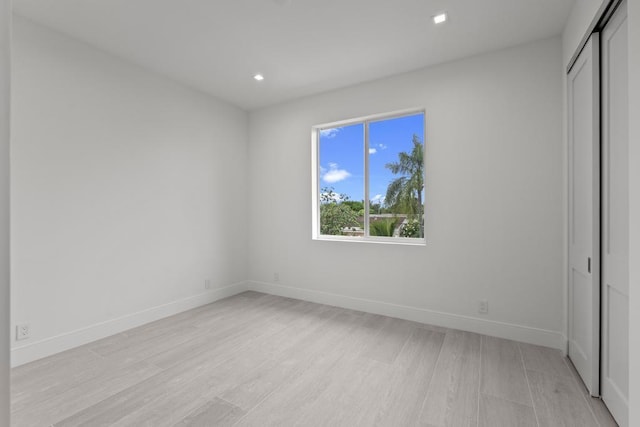 unfurnished bedroom featuring light hardwood / wood-style floors and a closet