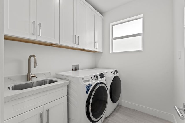 washroom featuring cabinets, sink, and washer and dryer