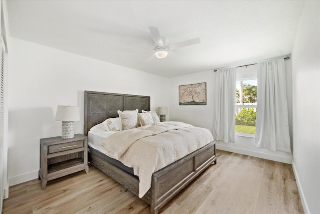 bedroom with light hardwood / wood-style floors and ceiling fan