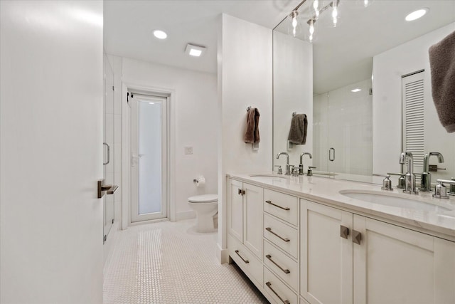 bathroom featuring vanity, toilet, a shower with shower door, and tile patterned flooring