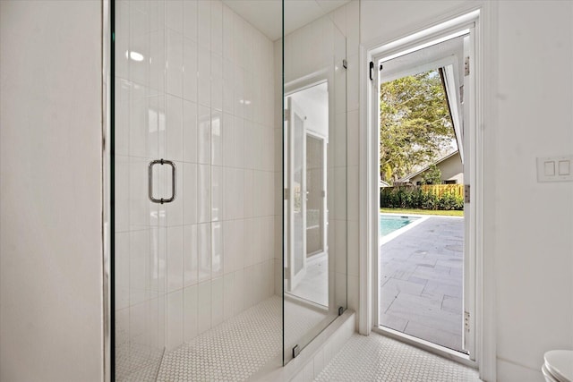 bathroom with a shower with shower door, tile patterned floors, and toilet