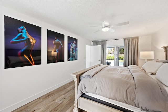 bedroom with ceiling fan, access to exterior, hardwood / wood-style floors, and a textured ceiling