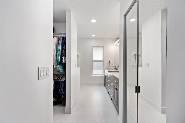 bathroom featuring vanity, tile patterned floors, and a textured ceiling