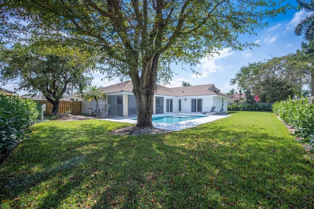 rear view of house featuring a yard and a patio