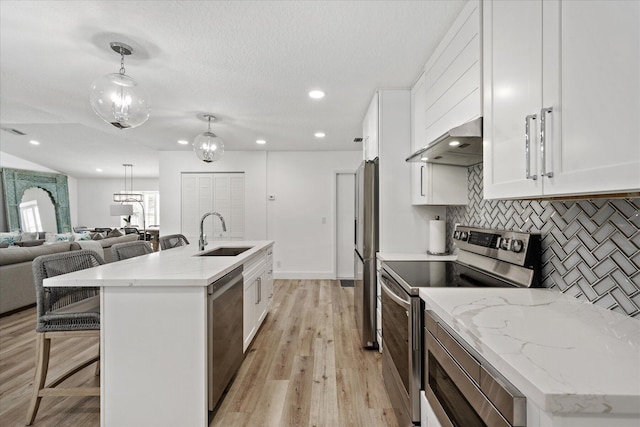 kitchen with sink, white cabinetry, an island with sink, pendant lighting, and stainless steel appliances