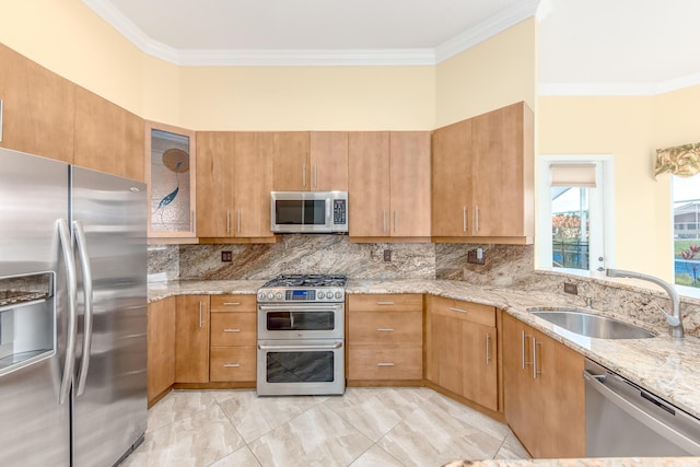 kitchen with appliances with stainless steel finishes, sink, decorative backsplash, crown molding, and light stone countertops