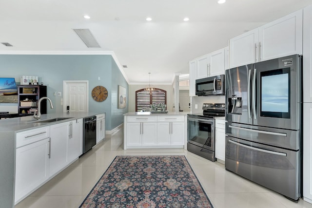 kitchen with light tile patterned floors, a peninsula, stainless steel appliances, white cabinetry, and a sink