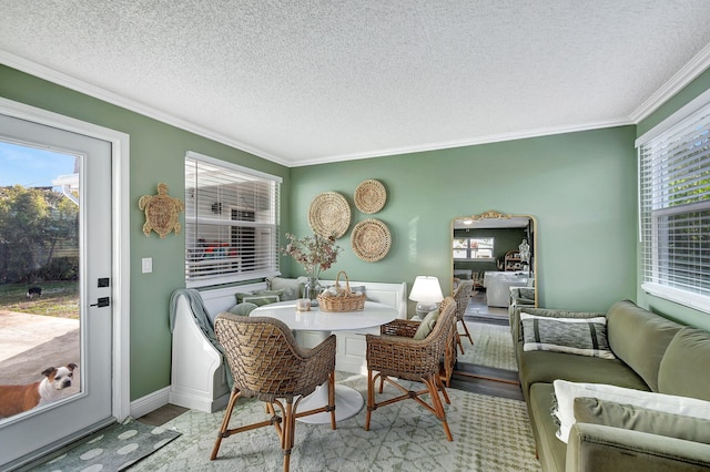 interior space featuring ornamental molding, a textured ceiling, and light wood-type flooring