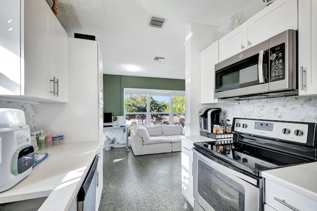 kitchen featuring decorative backsplash, stainless steel appliances, a textured ceiling, and white cabinets