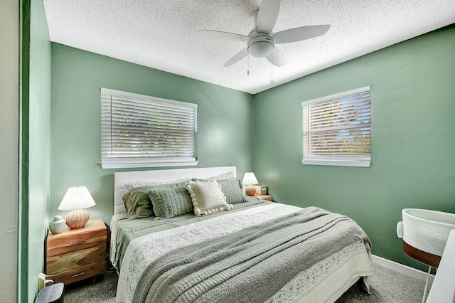 carpeted bedroom featuring ceiling fan and a textured ceiling