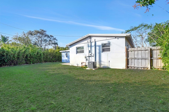 back of house featuring a yard and central AC unit