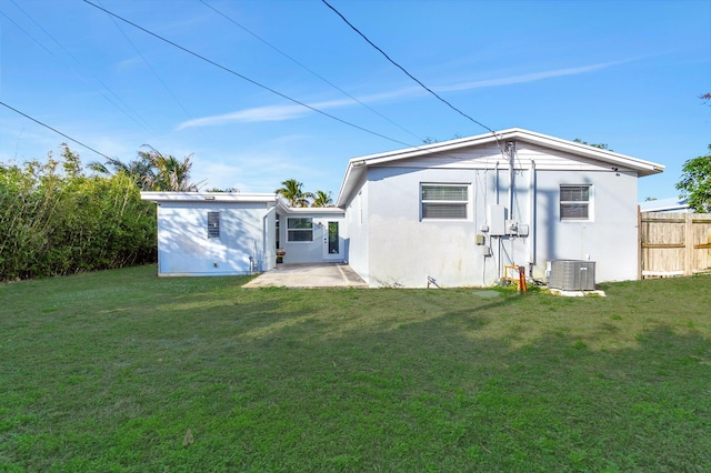 back of property featuring central AC, a lawn, and a patio