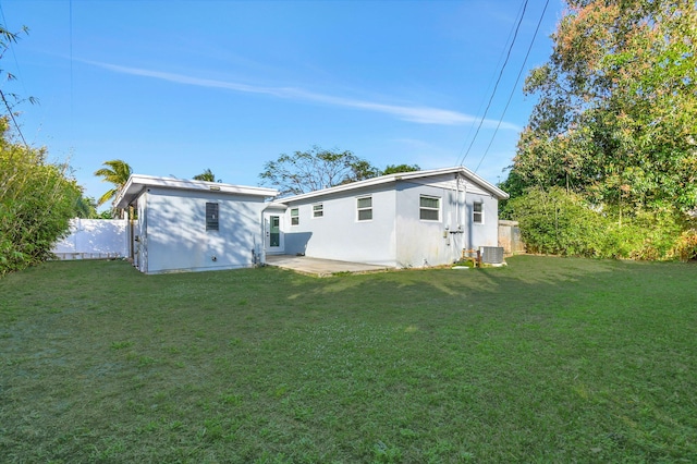 back of house with a yard and central air condition unit