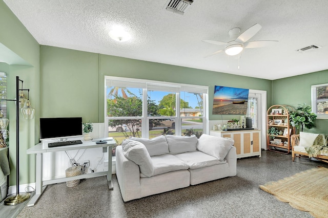 living room with ceiling fan and a textured ceiling