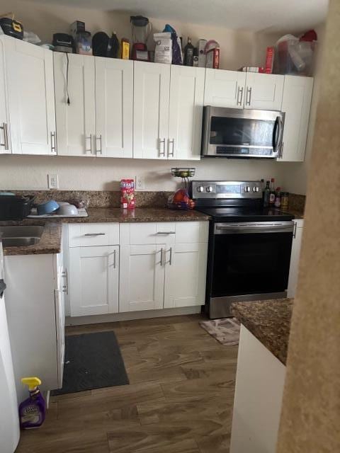 kitchen with white cabinetry, appliances with stainless steel finishes, dark wood-type flooring, and sink