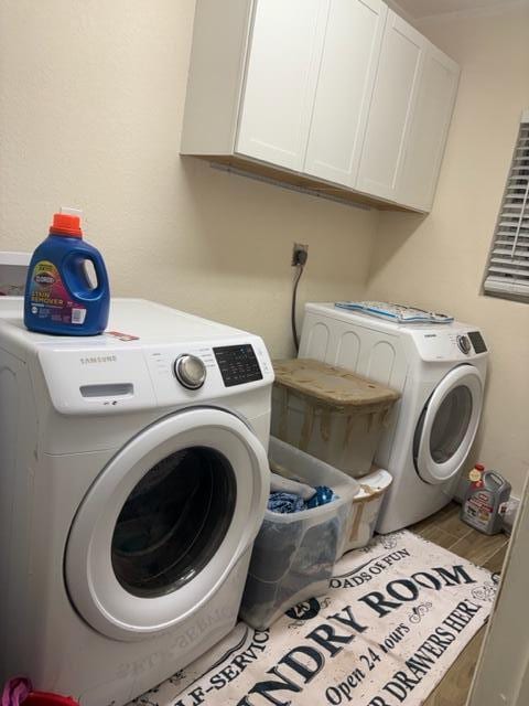 laundry room with cabinets, separate washer and dryer, and light hardwood / wood-style flooring