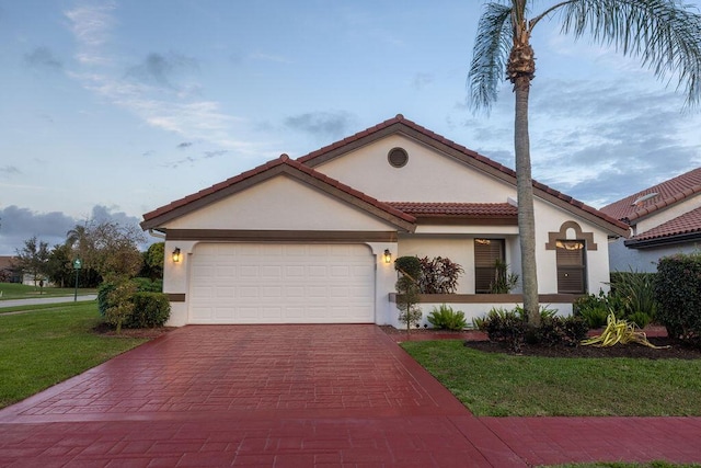 mediterranean / spanish-style home with a garage and a front lawn