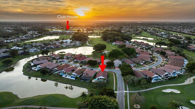 aerial view at dusk featuring a water view