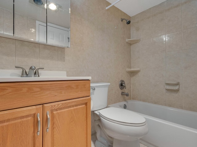 full bathroom featuring tile walls, vanity, toilet, and tiled shower / bath