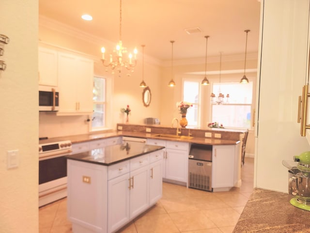 kitchen featuring dark countertops, ornamental molding, stove, white cabinetry, and a sink