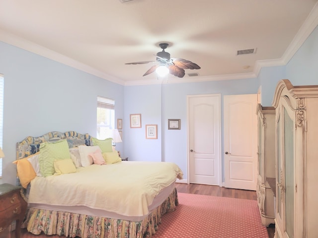 bedroom featuring dark wood finished floors, a ceiling fan, visible vents, and ornamental molding