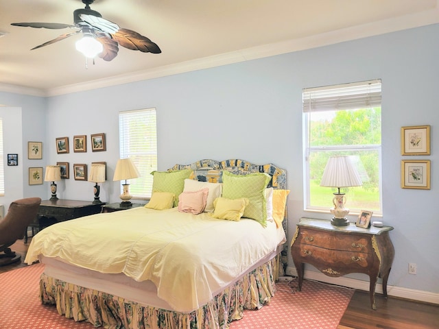 bedroom featuring crown molding, multiple windows, wood finished floors, and baseboards