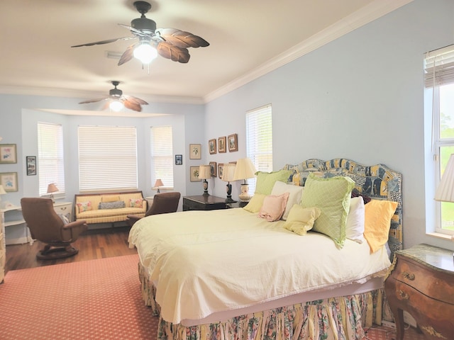 bedroom with a ceiling fan, crown molding, multiple windows, and wood finished floors