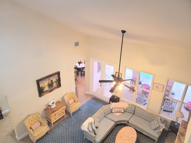 tiled living area featuring visible vents, ceiling fan, high vaulted ceiling, and baseboards