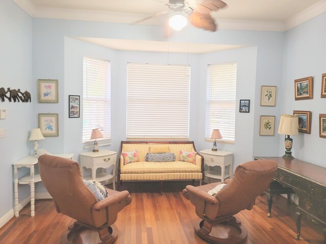 living room with baseboards, wood finished floors, a ceiling fan, and ornamental molding