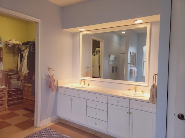 full bath featuring double vanity, a spacious closet, and a sink