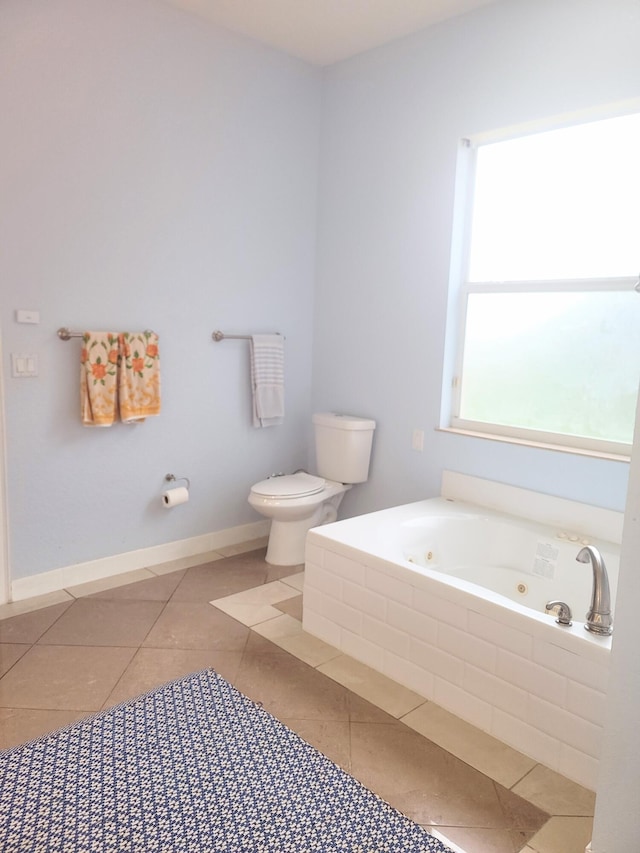 full bathroom with tile patterned floors, baseboards, toilet, and a whirlpool tub