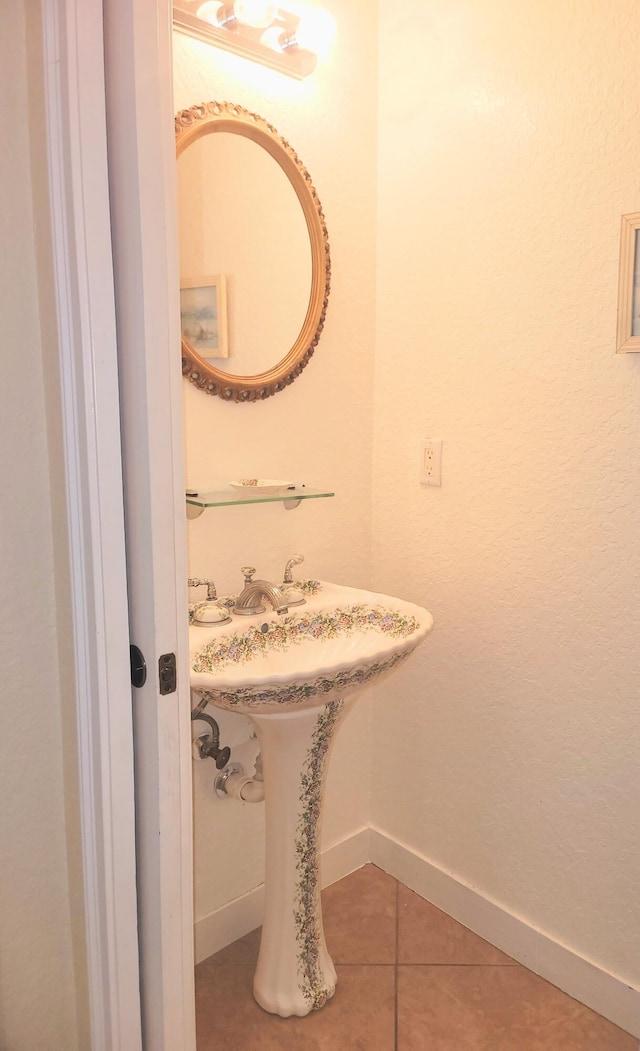 bathroom with baseboards and tile patterned flooring