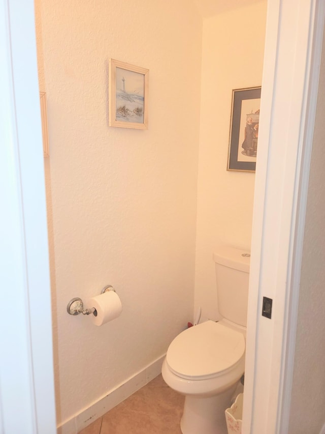 bathroom featuring tile patterned floors, baseboards, and toilet