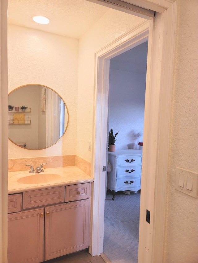 bathroom featuring vanity and a textured wall