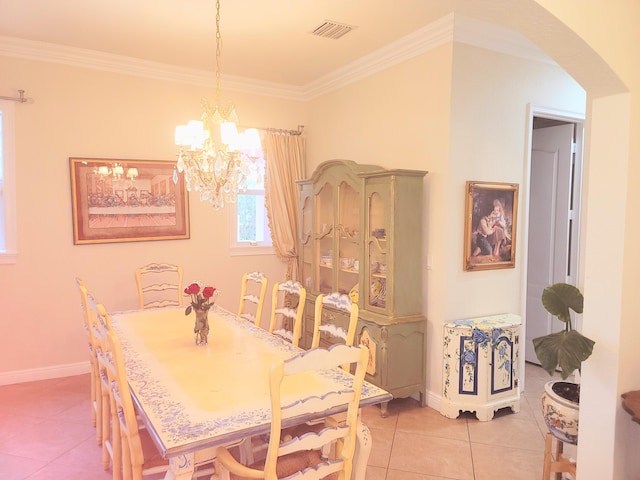 dining room with visible vents, ornamental molding, arched walkways, light tile patterned floors, and baseboards