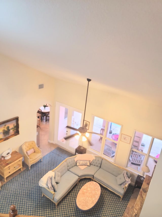 living room with a wealth of natural light, visible vents, lofted ceiling, and carpet