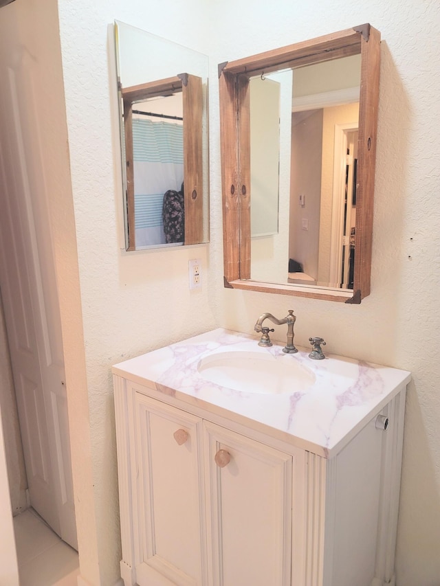 bathroom featuring vanity and a textured wall