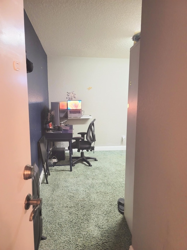 carpeted office featuring baseboards and a textured ceiling