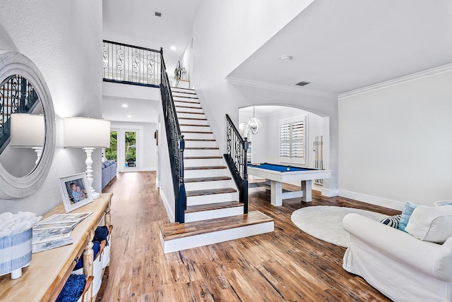 foyer featuring stairway, wood finished floors, baseboards, visible vents, and ornamental molding