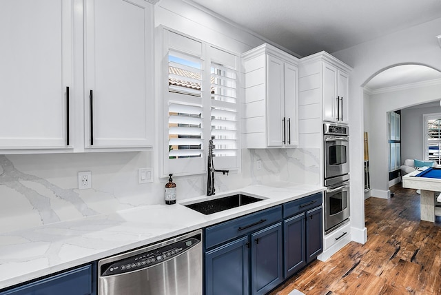 kitchen featuring ornamental molding, stainless steel appliances, white cabinets, and blue cabinetry