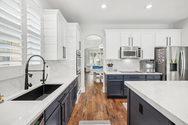 kitchen with tasteful backsplash, white cabinetry, appliances with stainless steel finishes, and sink