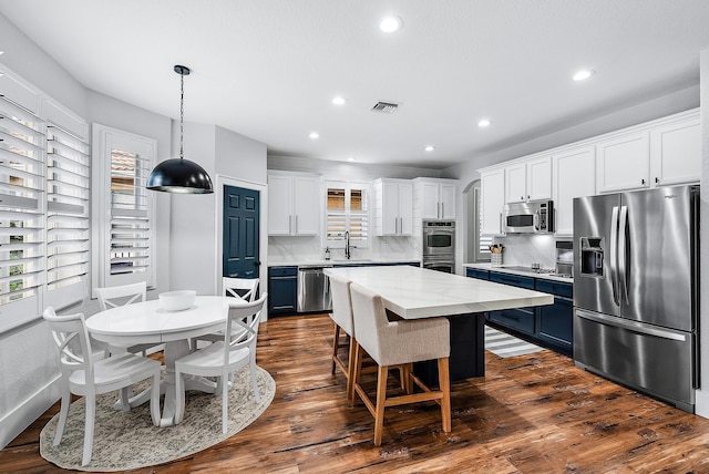 kitchen featuring a kitchen island, sink, white cabinets, stainless steel appliances, and blue cabinetry