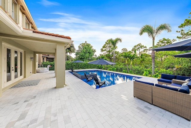 view of pool with a patio, a fenced in pool, french doors, and an outdoor living space