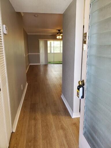 hall with baseboards and wood finished floors