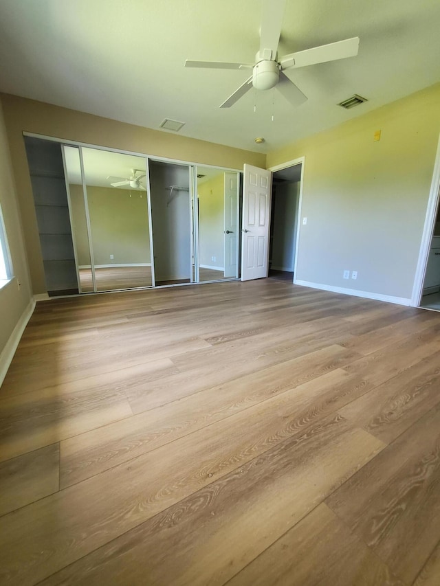 unfurnished bedroom with visible vents, baseboards, wood finished floors, and a ceiling fan